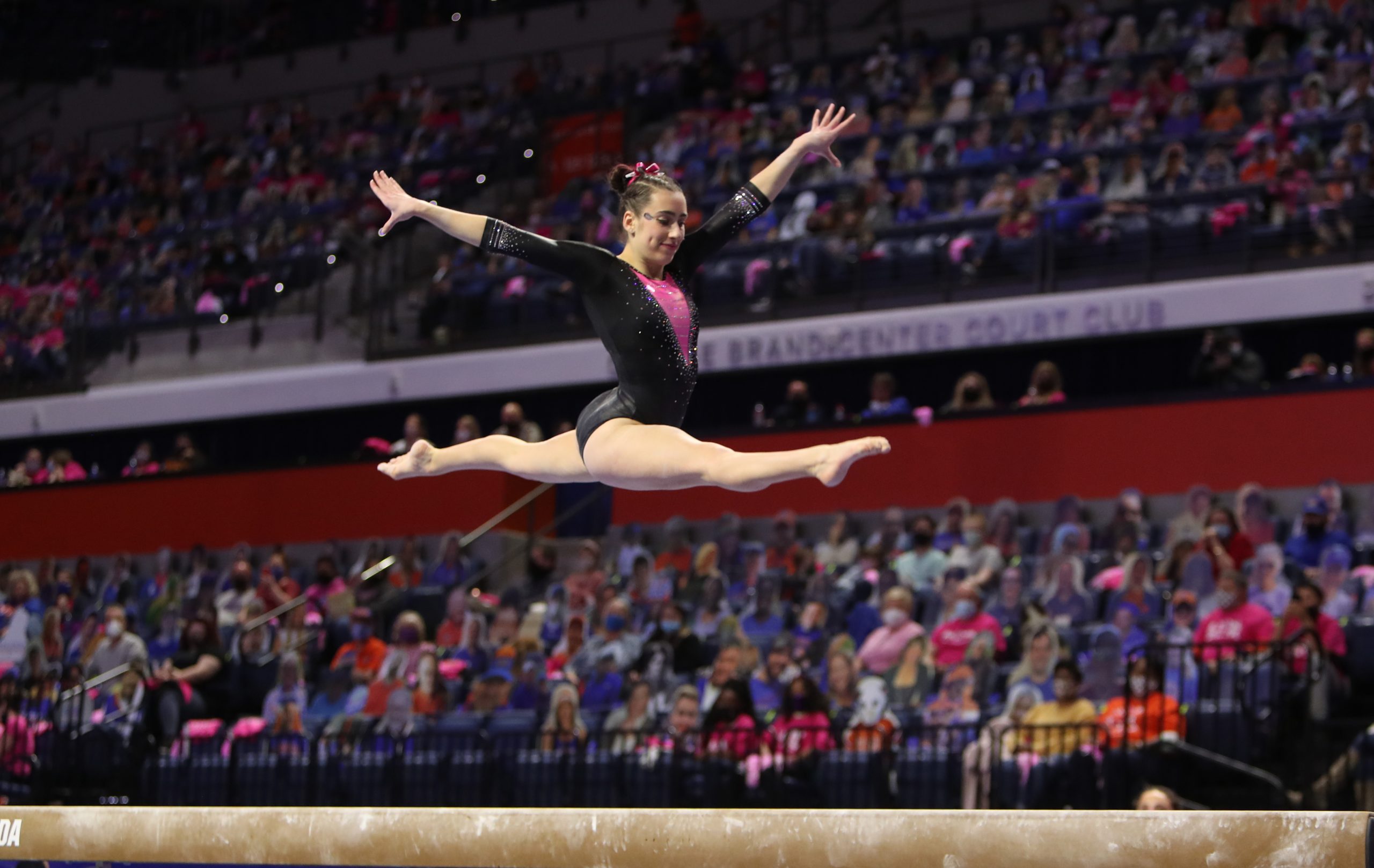 Leah Clapper leaping on beam during the 2021 link to pink meet 